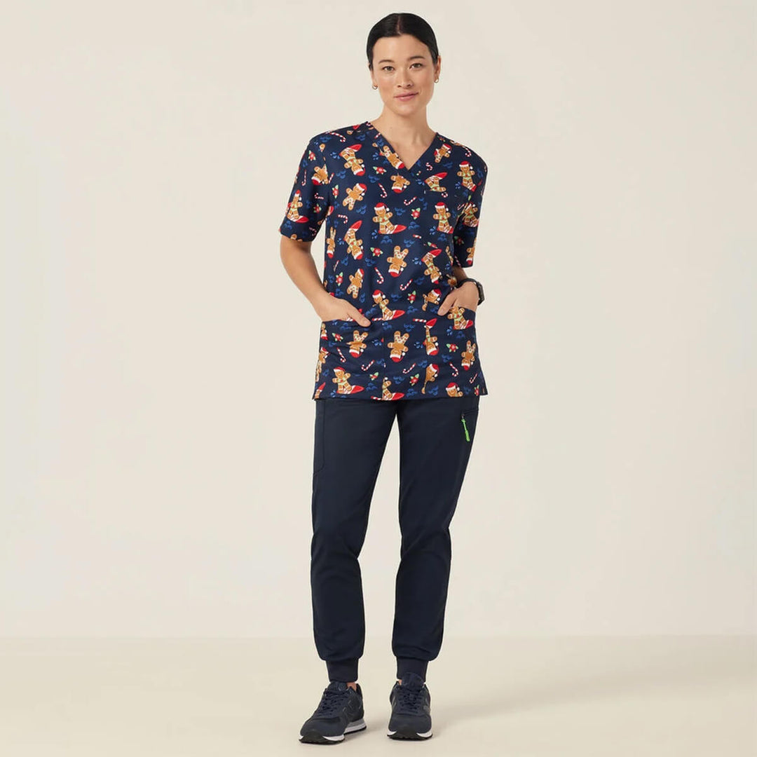 NNT CATUXV XMAS Gingerbread Surfer Print Scrub Top Midnight worn by woman