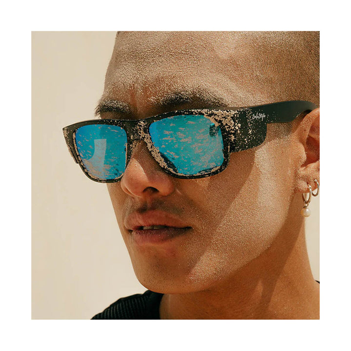 SafeStyle Fusions Matte Black Frame Mirror Blue Polarised Lens worn by man covered in sand