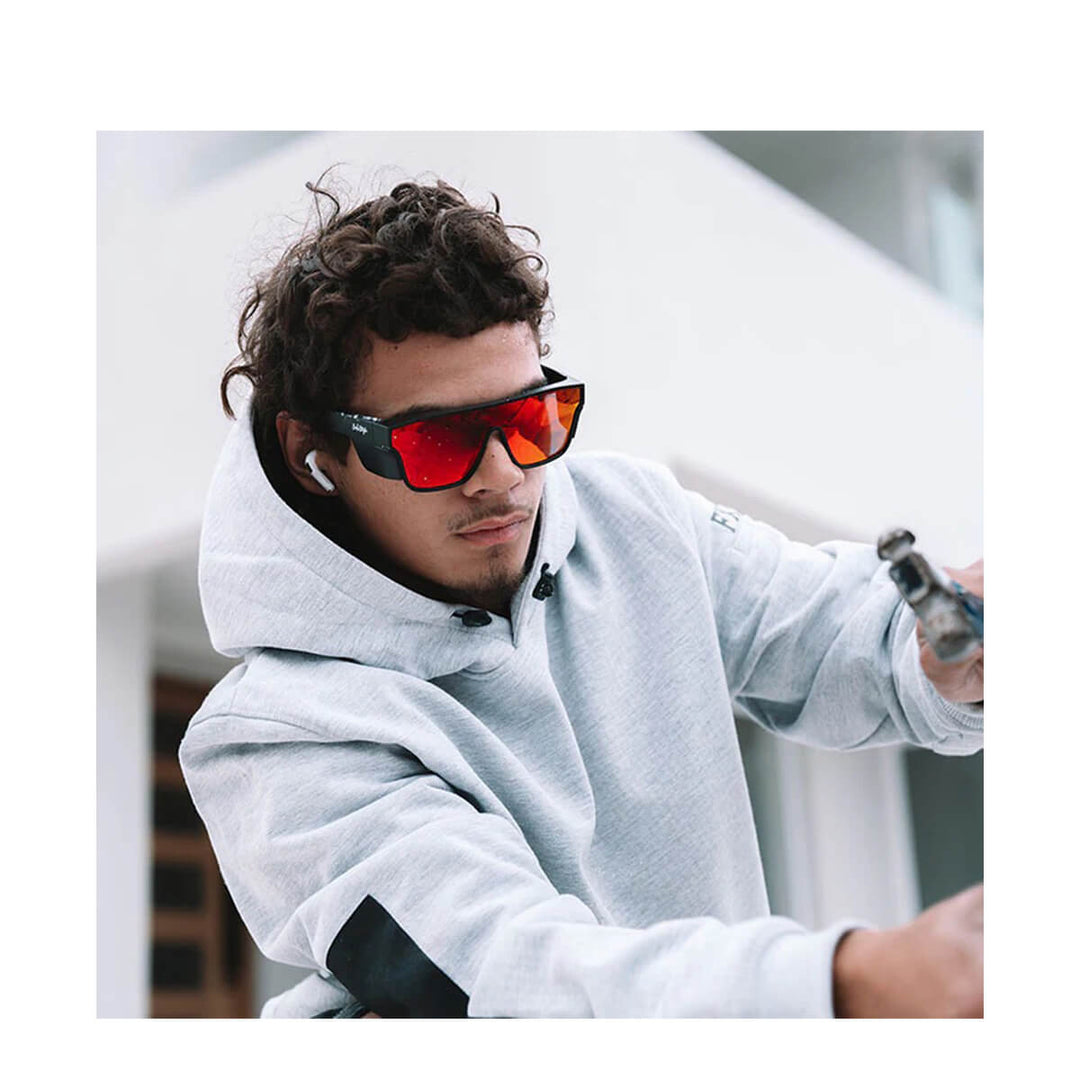 SafeStyle Primes Matte Black Frame Reflectors Red Lens Worn by man in grey hoodie, holding a hammer